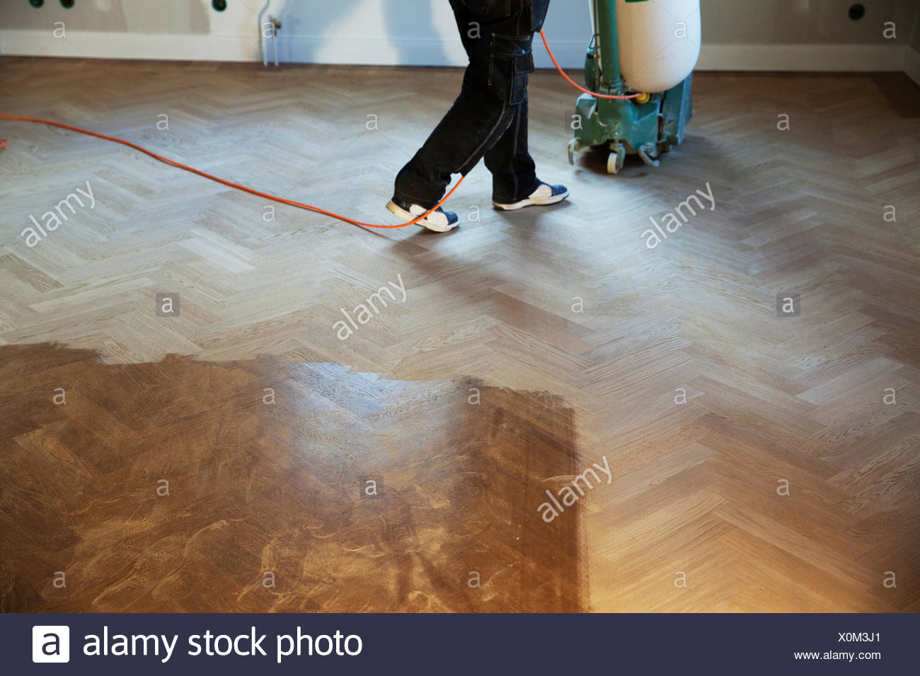 Man Cleaning Wooden Floor With Floor Polisher Stock Photo