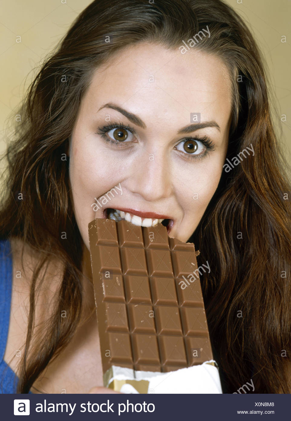 Junge Frau Beisst Genussvoll In Eine Grosse Tafel Schokolade