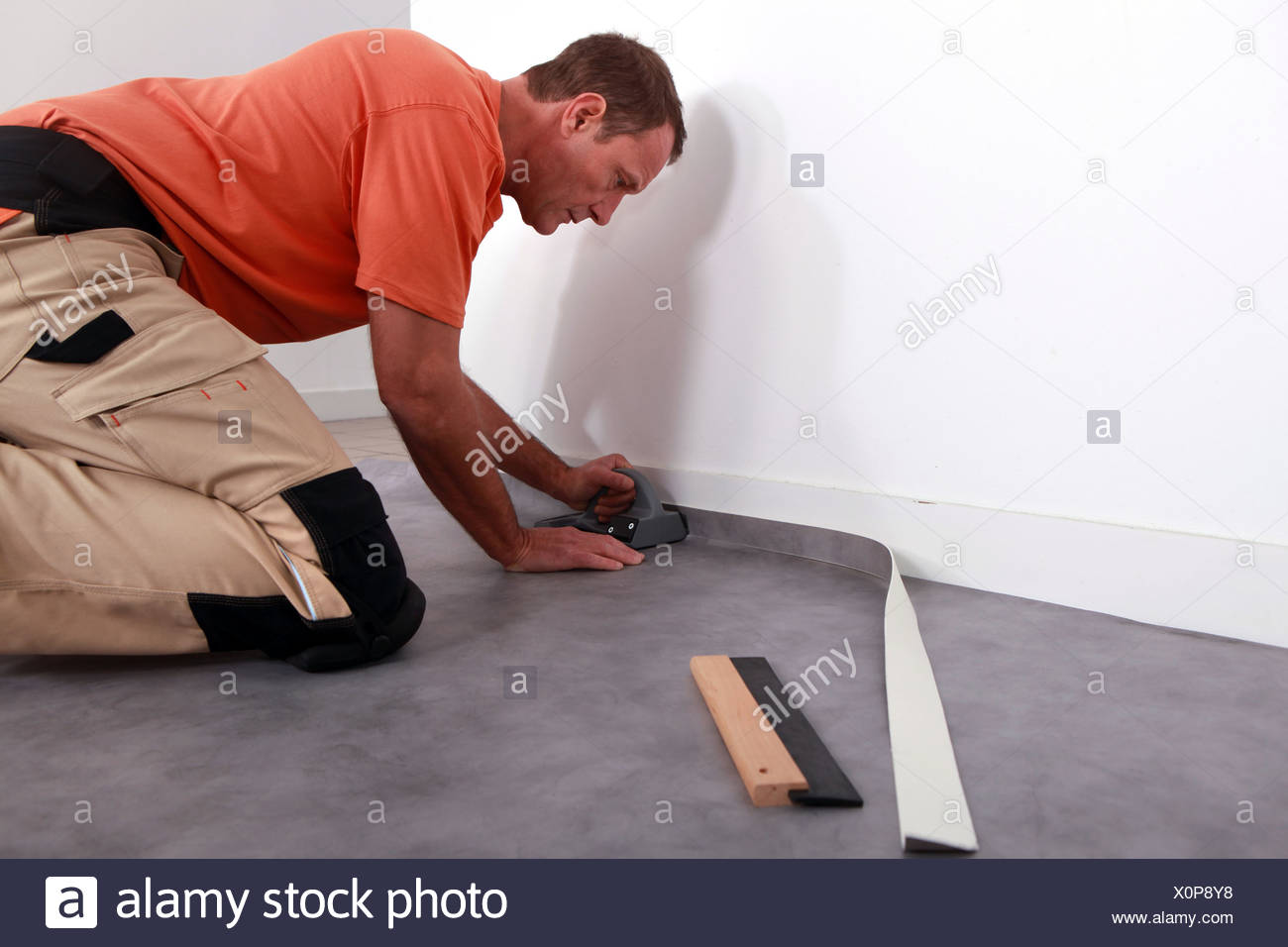 Man Putting Down Linoleum On A Baseboard Stock Photo 275855868