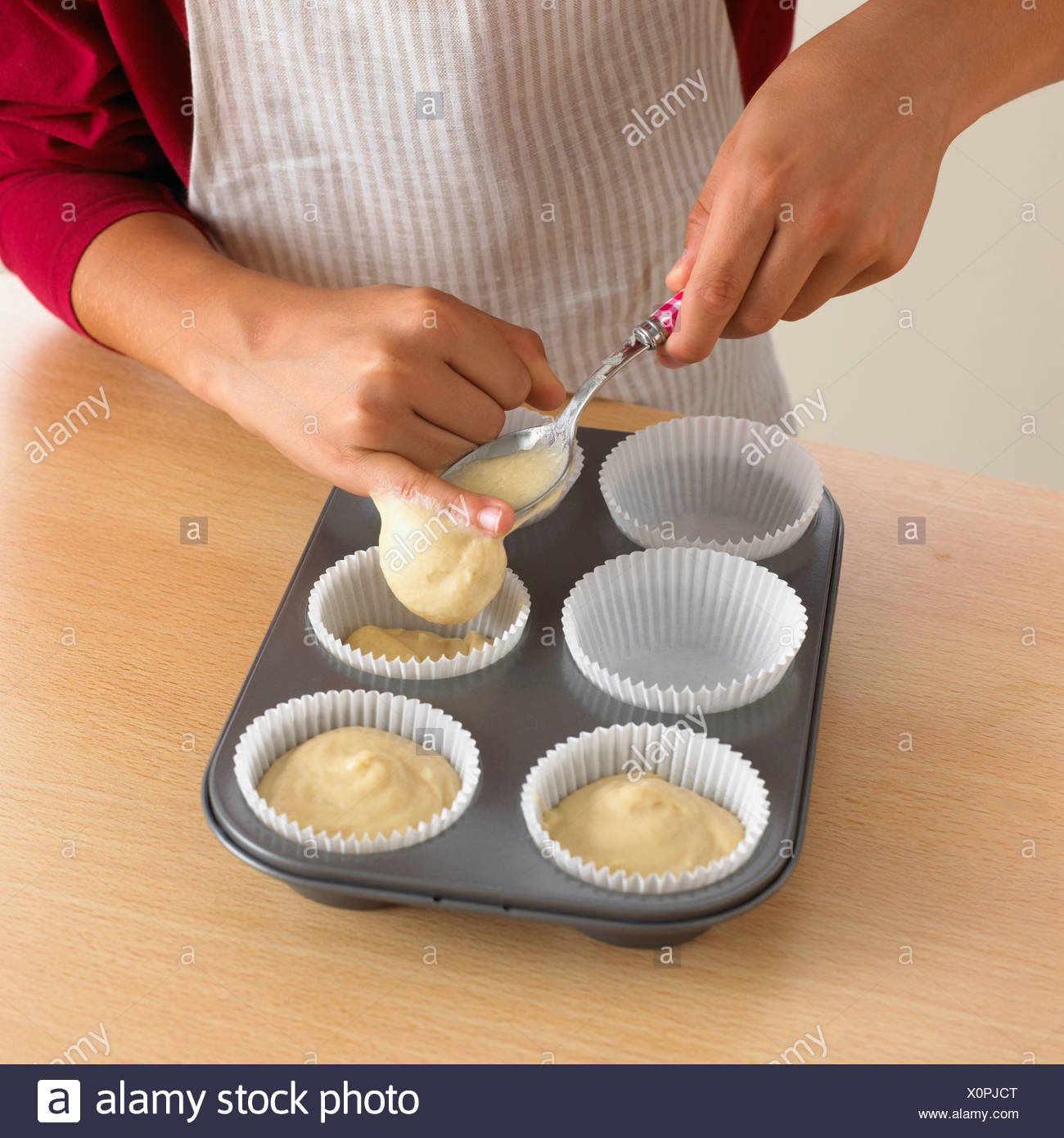 Woman Spooning Cake Batter Into Cupcake Cases Stock Photo Alamy