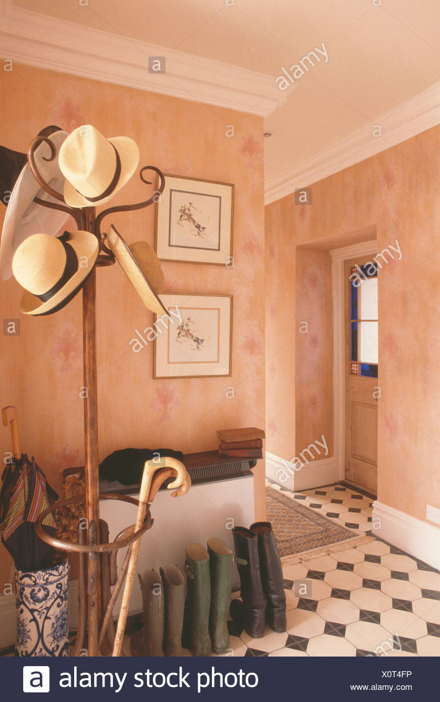 Straw Hats And Walking Sticks On Bentwood Hatstand Beside Boots In Terracotta Paint Effect Walls In Eighties Hall Stock Photo Alamy