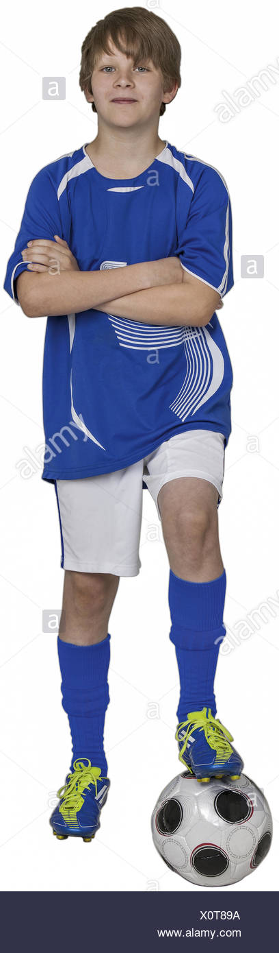 Junge steht mit einem Bein auf Fussball, verschraenkte Arme (model-released) Stock Photo