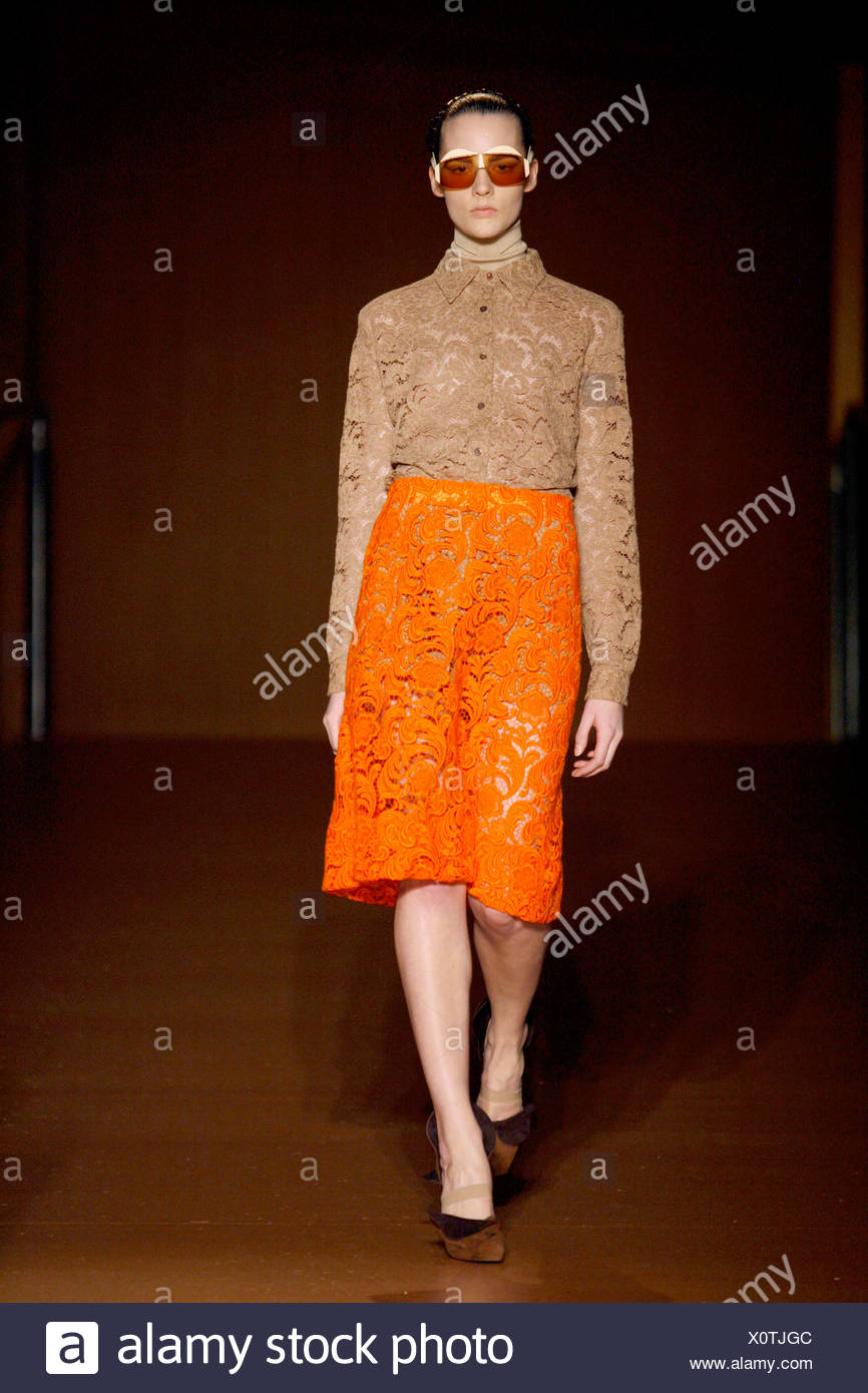 Prada Milan Ready to Wear Autumn Winter Model wearing orange knee length lace  skirt with a beige lace shirt Stock Photo - Alamy