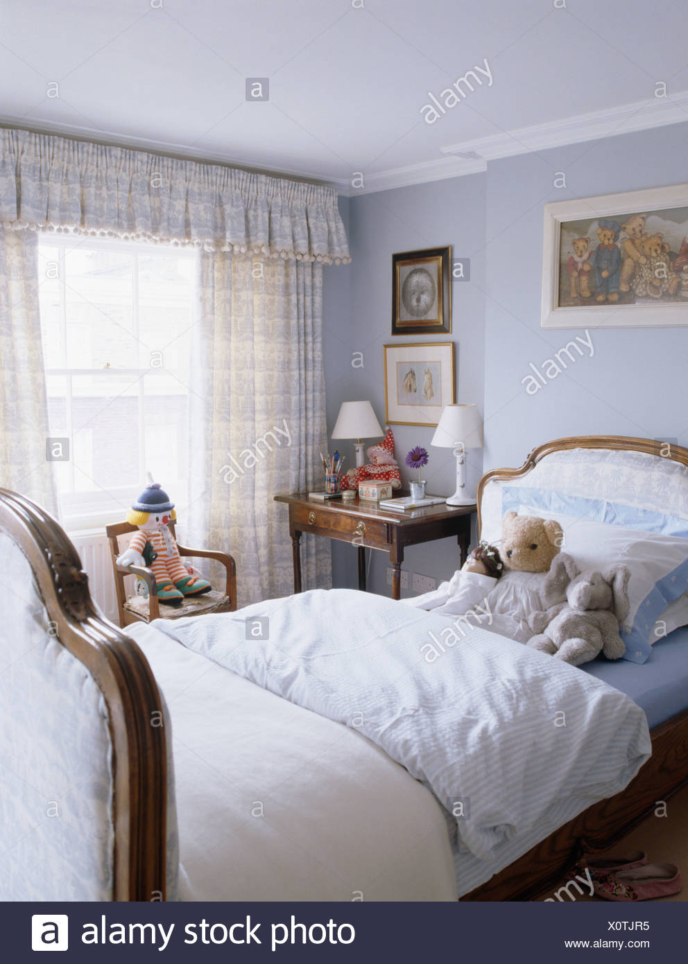 White Bedlinen And Soft Toys On Upholstered Bed In Child S