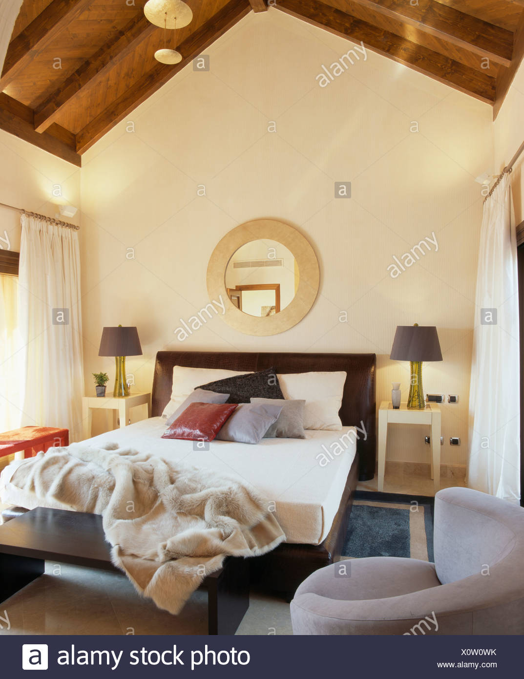 Circular Mirror Above Bed With Pale Cream Artificial Fur