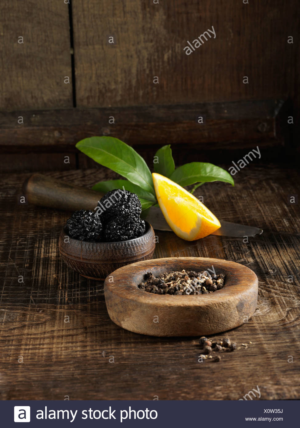 Black truffles, peppercorns and orange Stock Photo