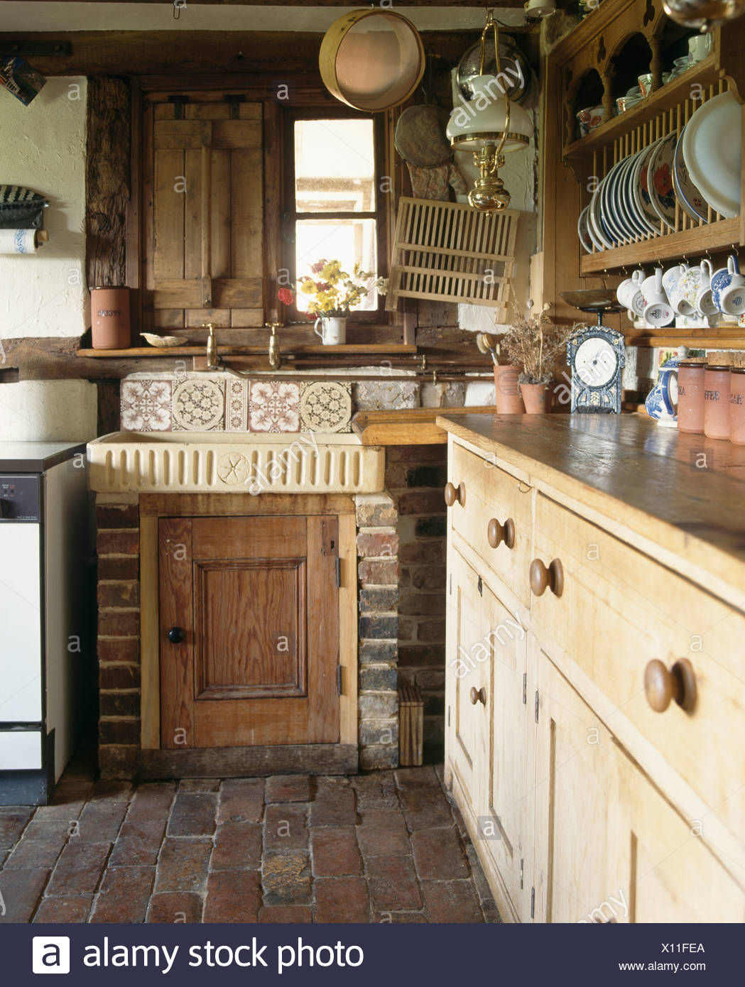 Earthenware Sink And Antique Pine Dresser In Small Cottage Kitchen
