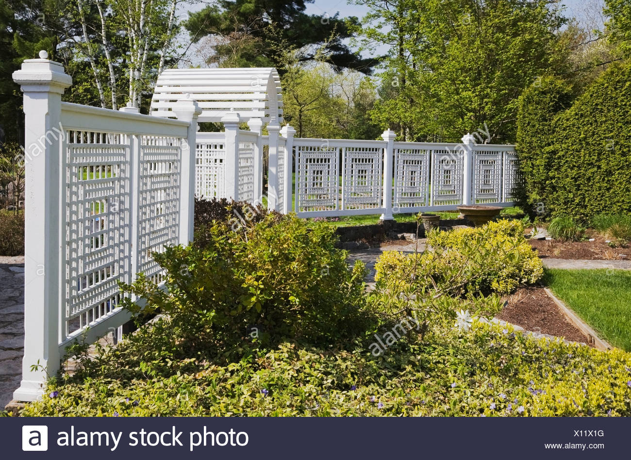 A White Wooden Fence With Trellis In A Landscaped Back Yard Garden In Spring Quebec Canada Stock Photo Alamy