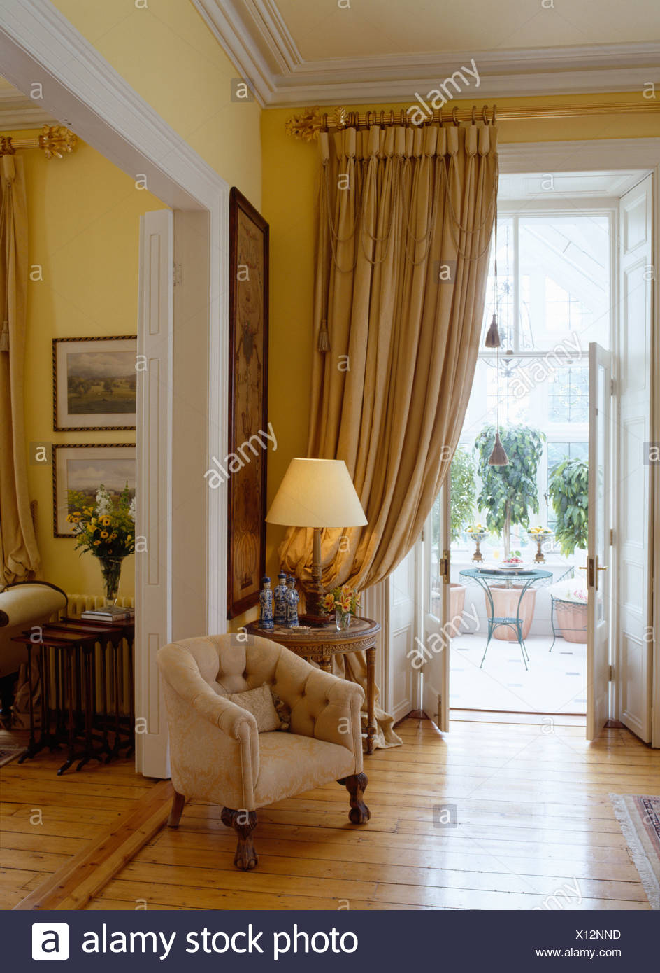 Cream Tub Chair Beside Double Doorway In Drawing Room With Lighted