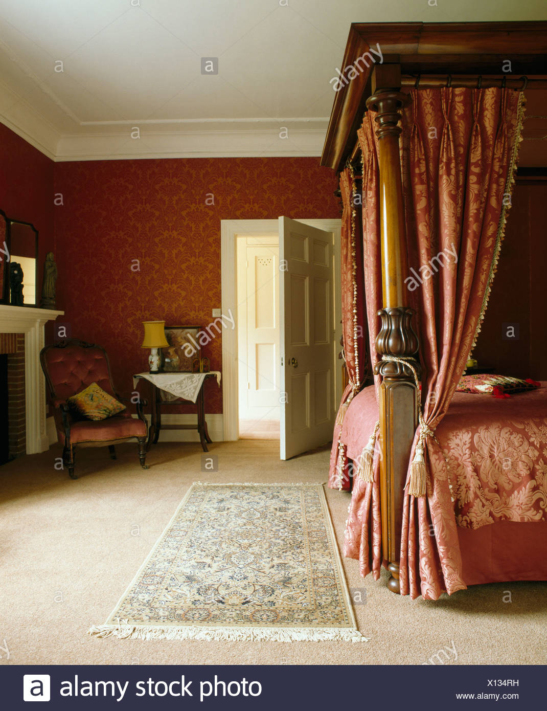 Red Damask Drapes On Antique Fourposter Bed In Red Bedroom