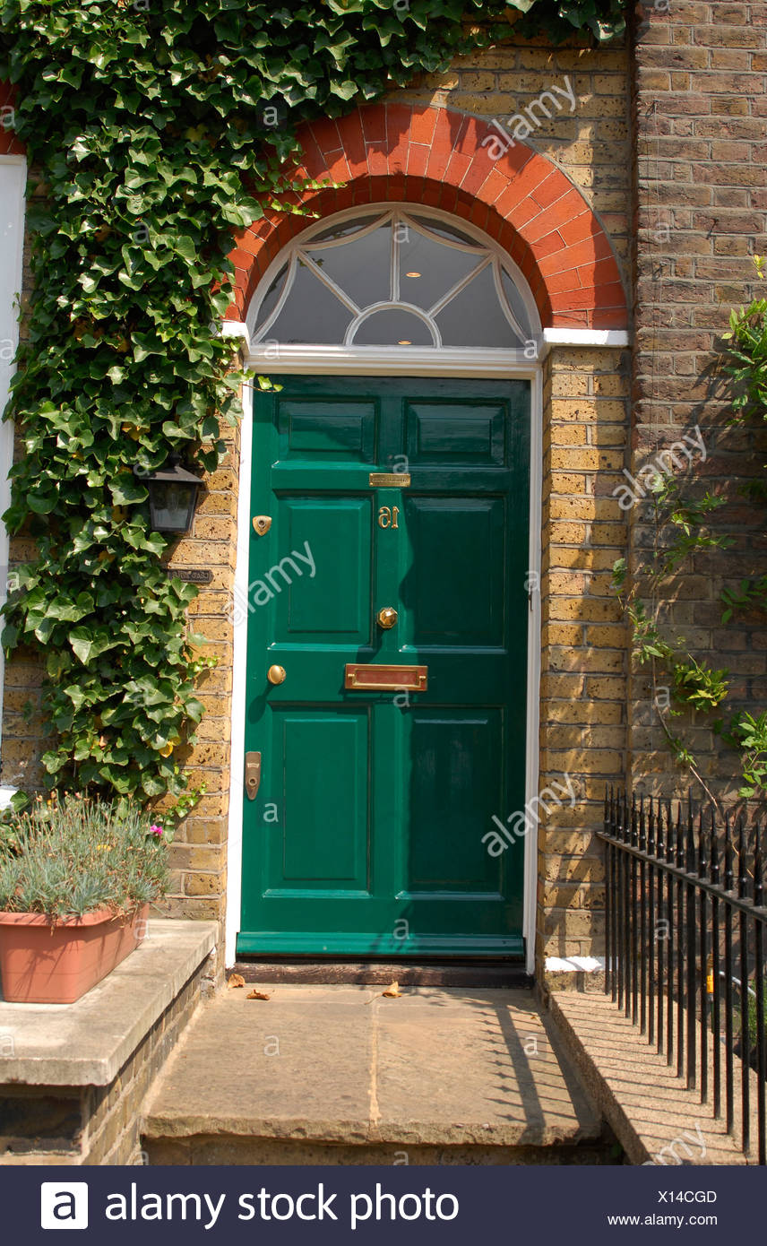 A Green Front Dowith Semi Circle Arched Window Above And Ivy
