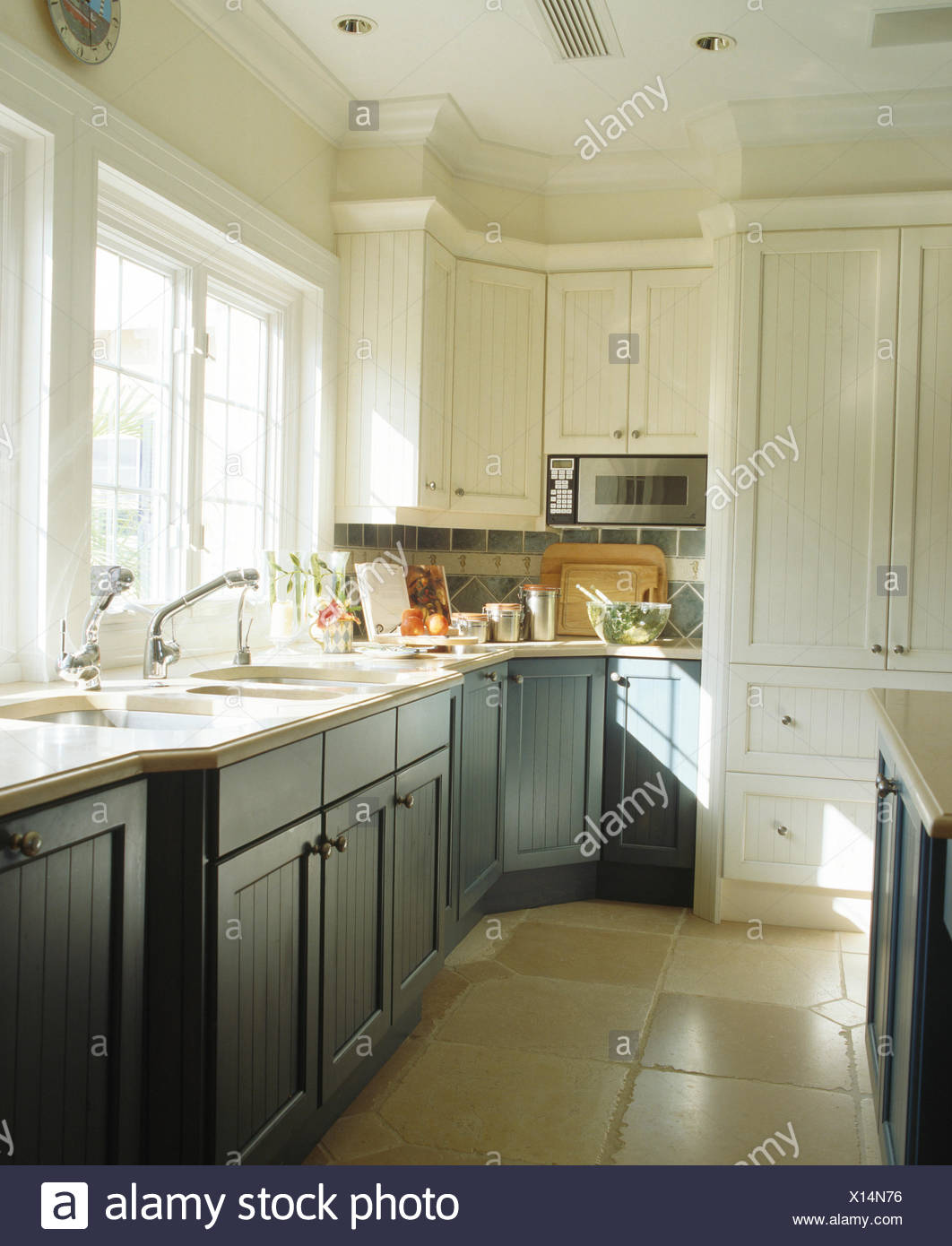 Blue Grey Fitted Cupboards In White Kitchen With Stone Tiled Floor Stock Photo Alamy