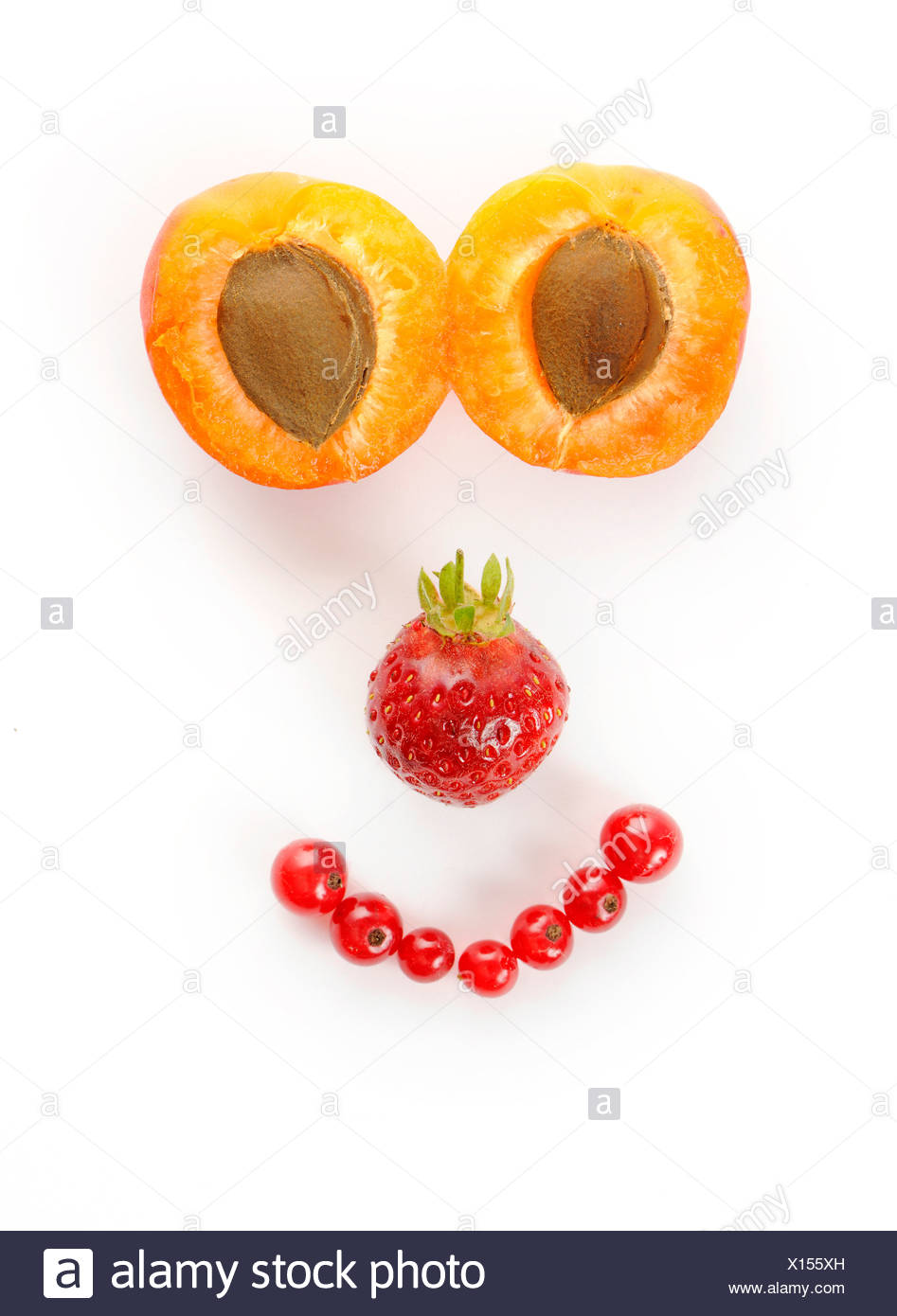 Face made of fruit, Apricots (Prunus armeniaca), Strawberries (Fragaria), Currants (Ribes) Stock Photo