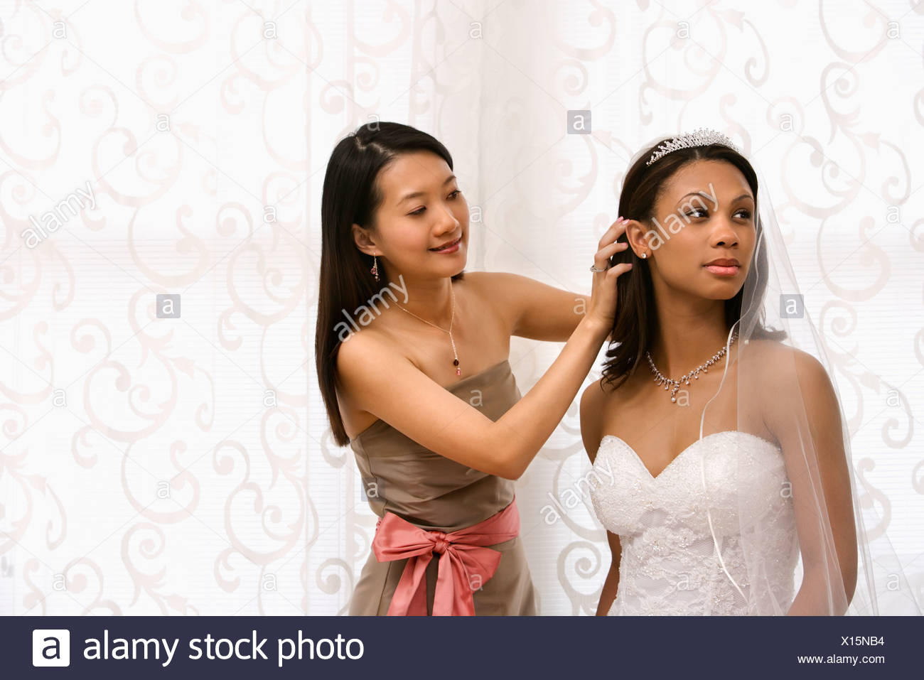 Asian Bridesmaid Fixing African American Bride S Hair Stock Photo