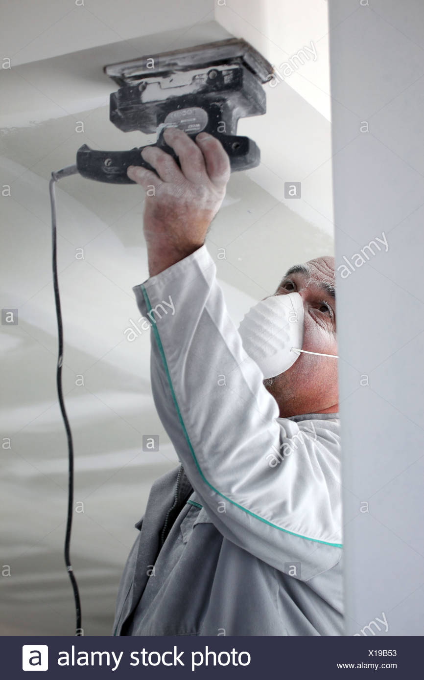 Decorator Sanding A Plaster Ceiling Stock Photo 276186879