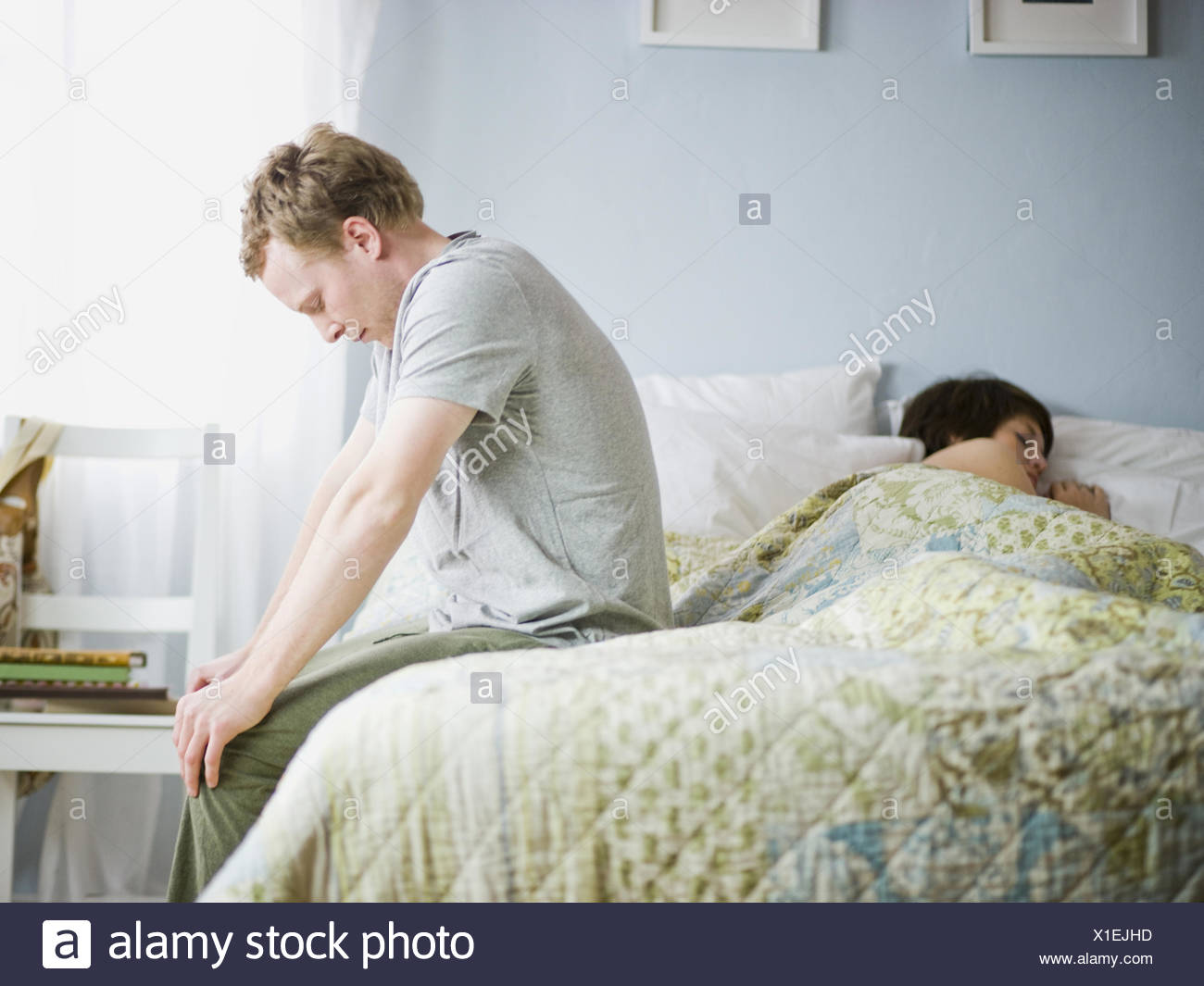 Man Sitting On The Edge Of A Bed Stock Photo Alamy