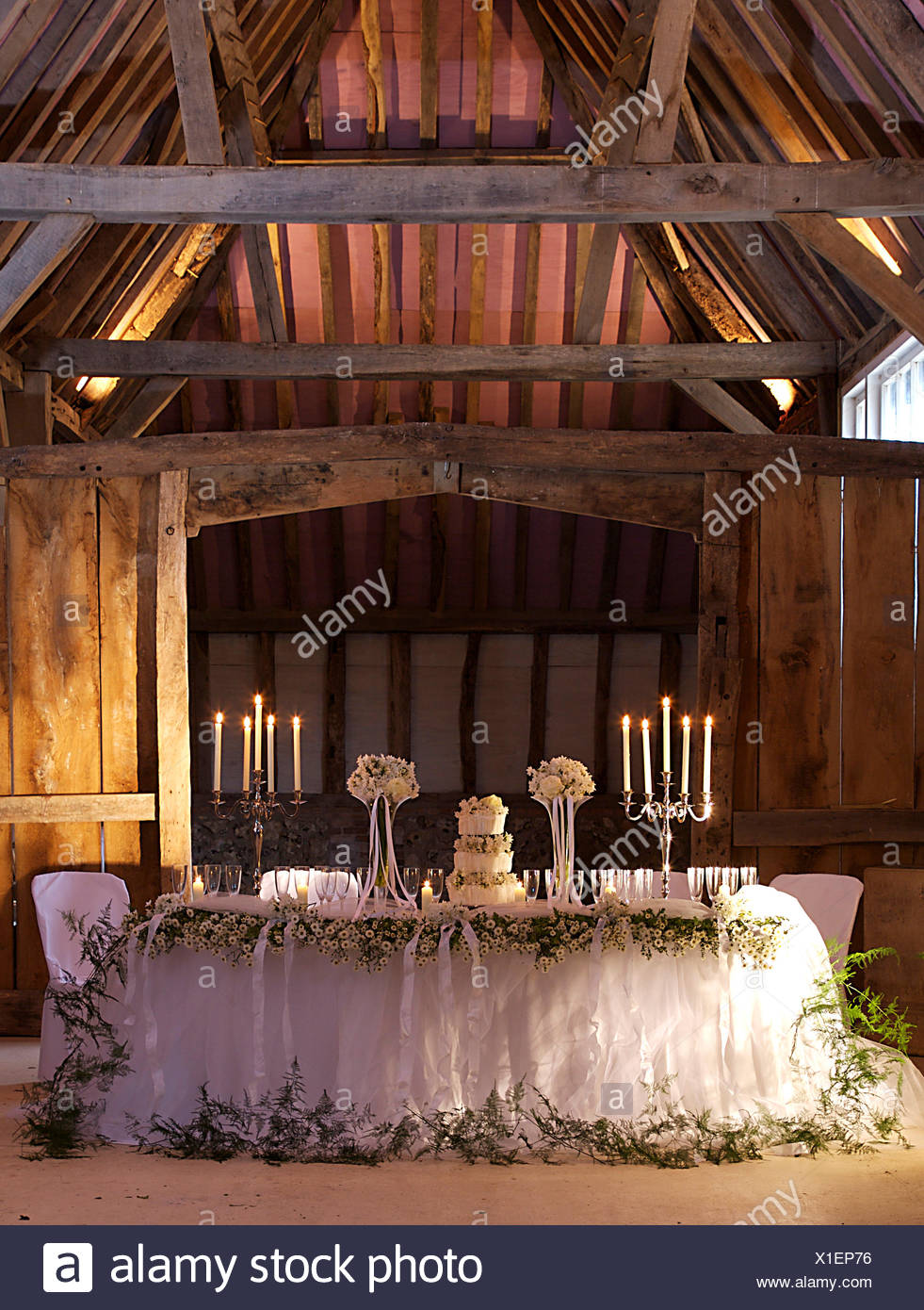Candelabra And A Three Tier Cake On Table With Set For A Wedding