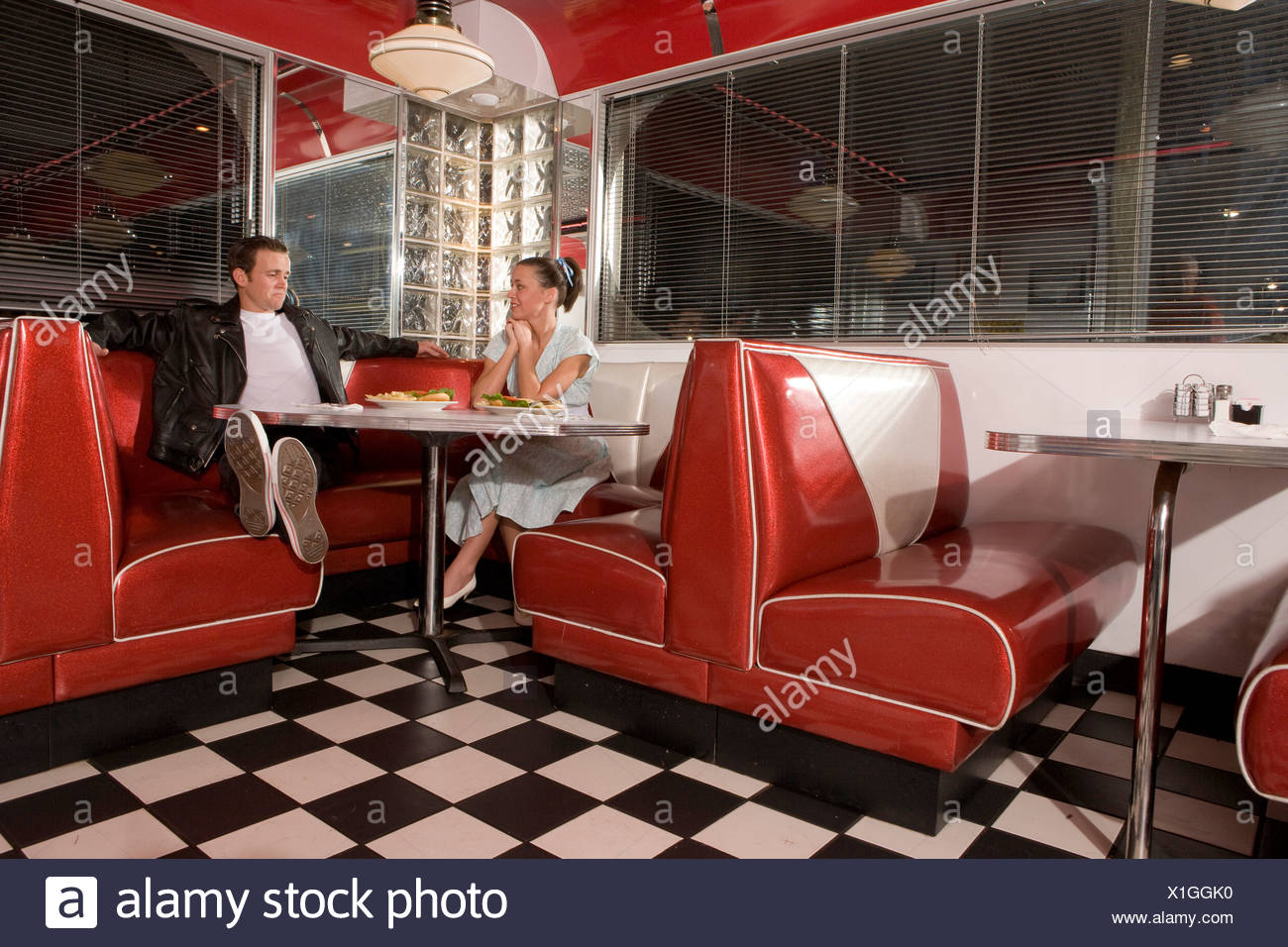Young couple on a date in old-fashioned 50s style diner talking and  relaxing Stock Photo - Alamy