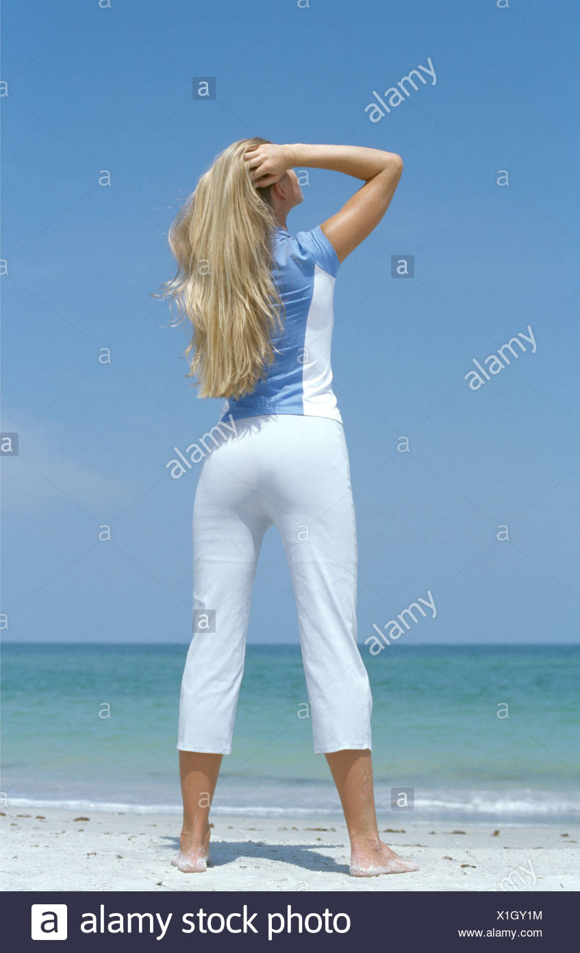 Back View Of Female Long Blonde Hair Wearing Blue And White Top