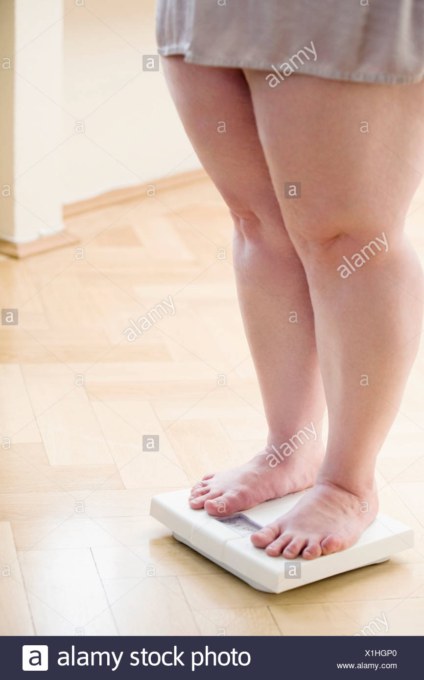 Legs Of Overweight Woman Checking Her Weight On Bathroom Scales Stock Photo Alamy