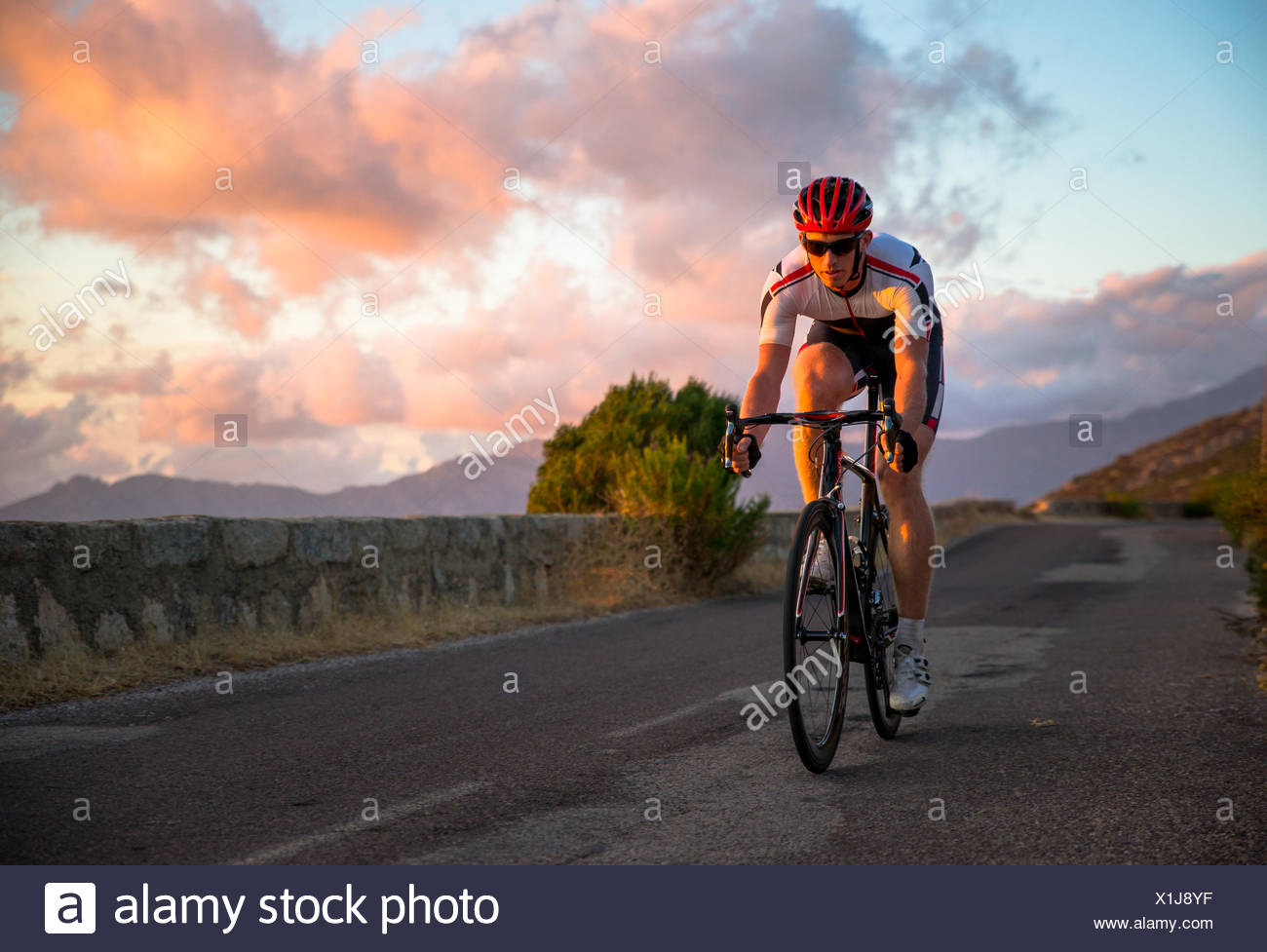 Man cycling at sunset, Corsica, France Stock Photo