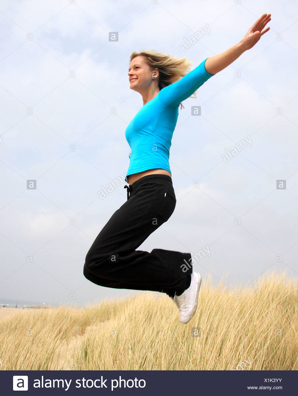 Female Blonde Hair Wearing A Turquoise Top Cropped Sleeves Black