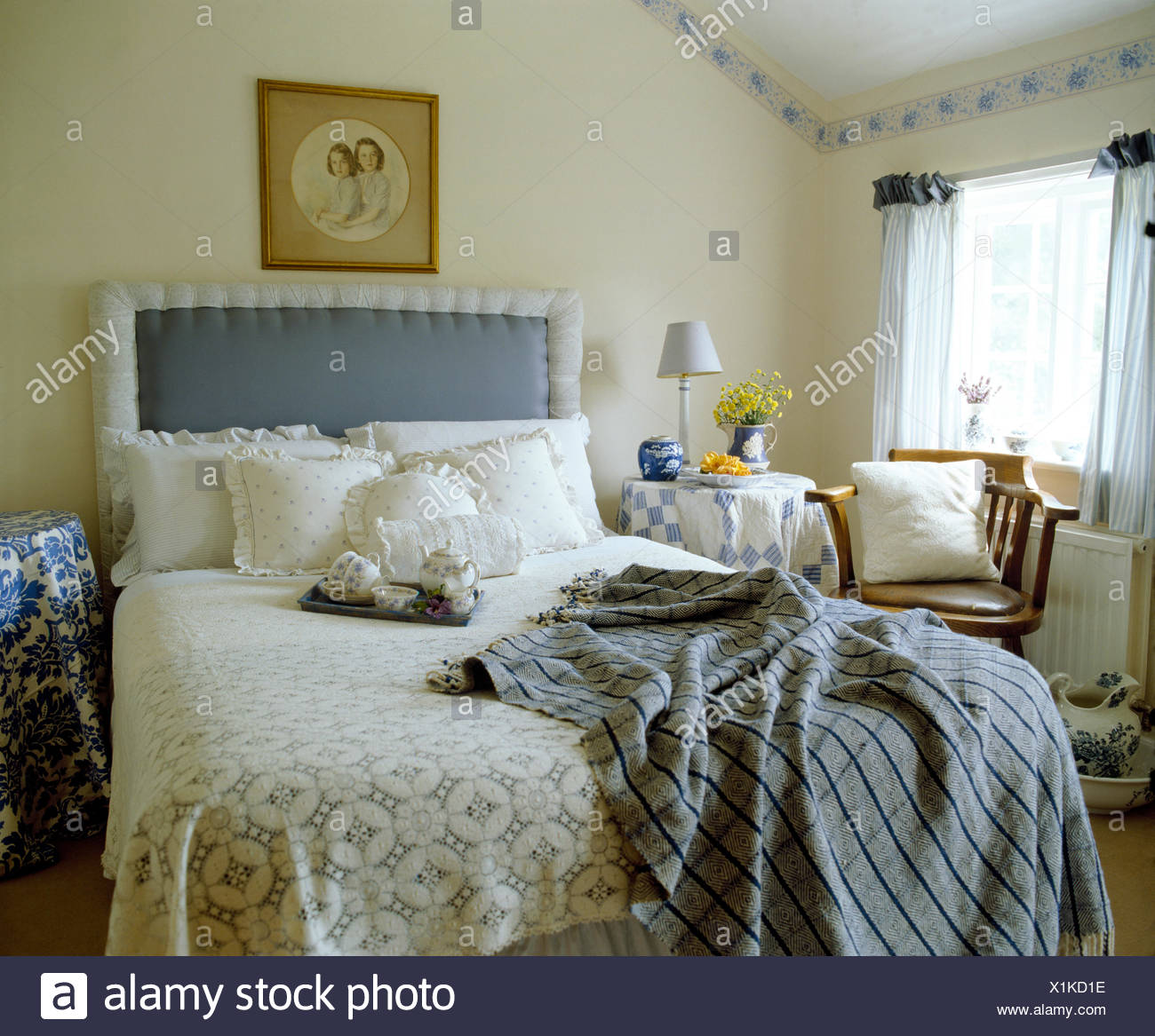 Cottage Bedroom With Blue Upholstered Headboard On Bed With Frilled Cushions And Blue Checked Throw Stock Photo Alamy