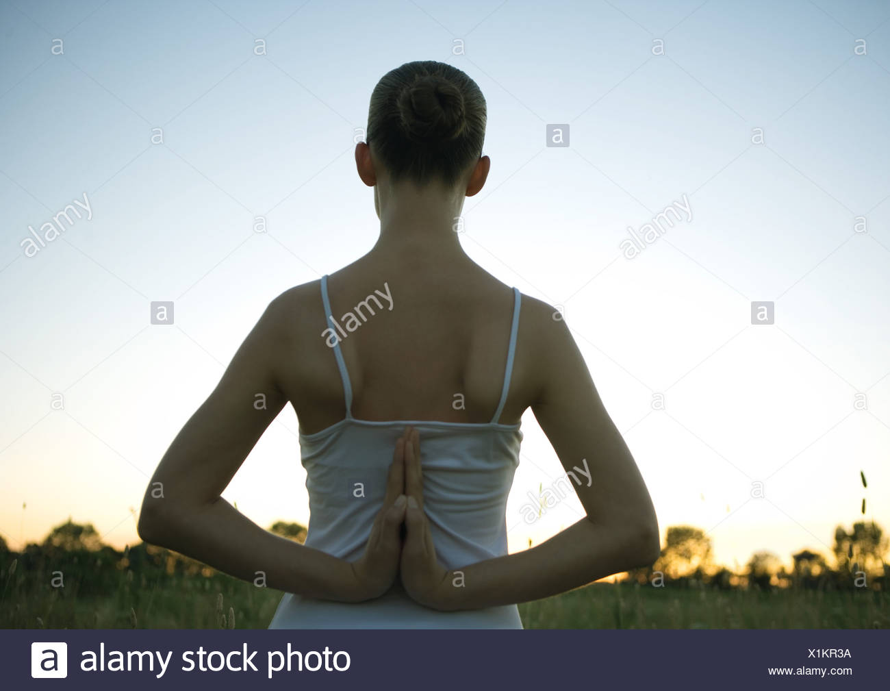 pose, back, clasped hands ... behind yoga sunset Woman at doing