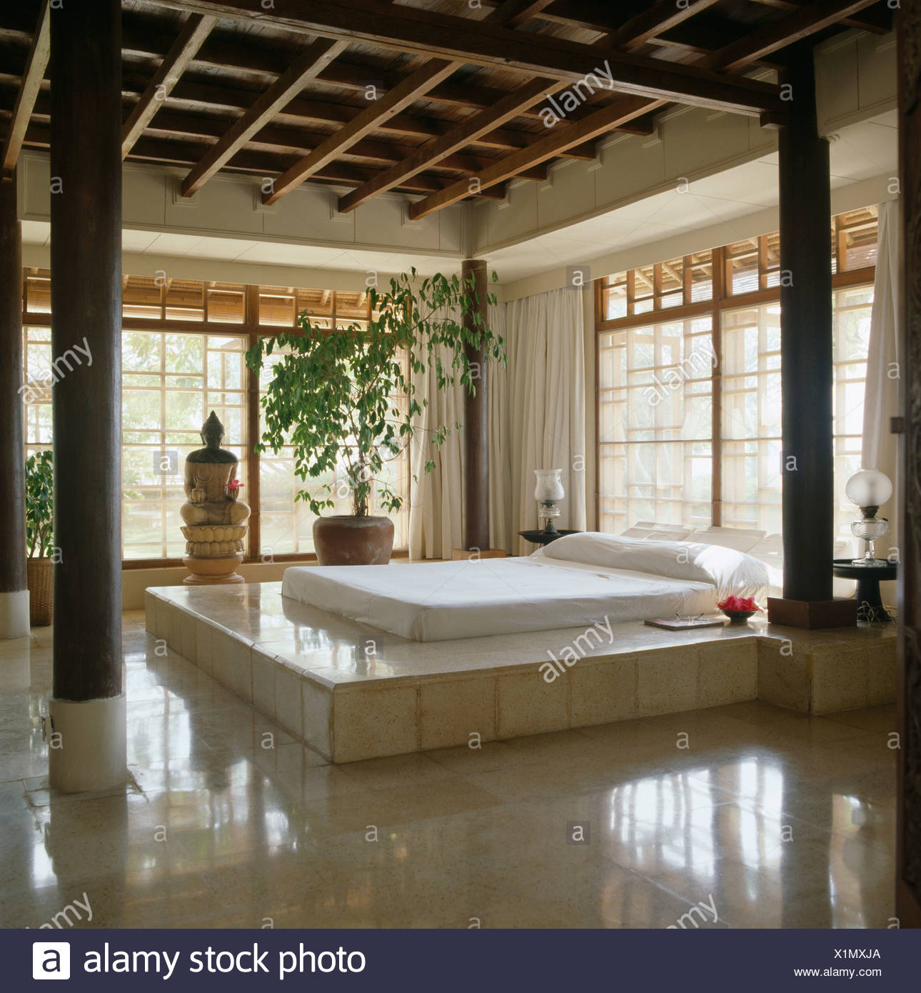 White Pillow And Bed Cover On White Tiled Raised Bed In