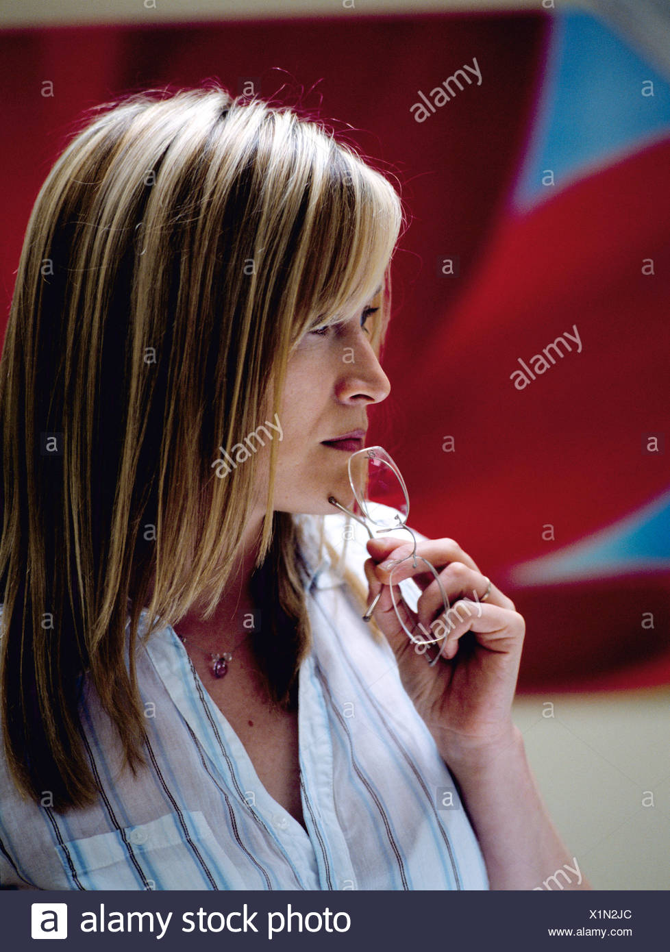 Female Long Blonde Hair Wearing Silver Necklace And White Blouse