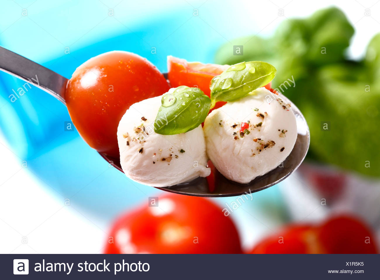Tomatoes, mozzarella and basil on a spoon Stock Photo