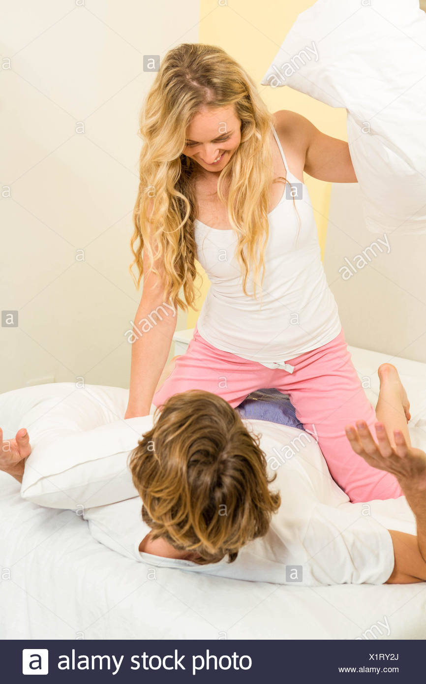 Cute Couple Pillow Fighting On Their Bed Stock Photo 276506682