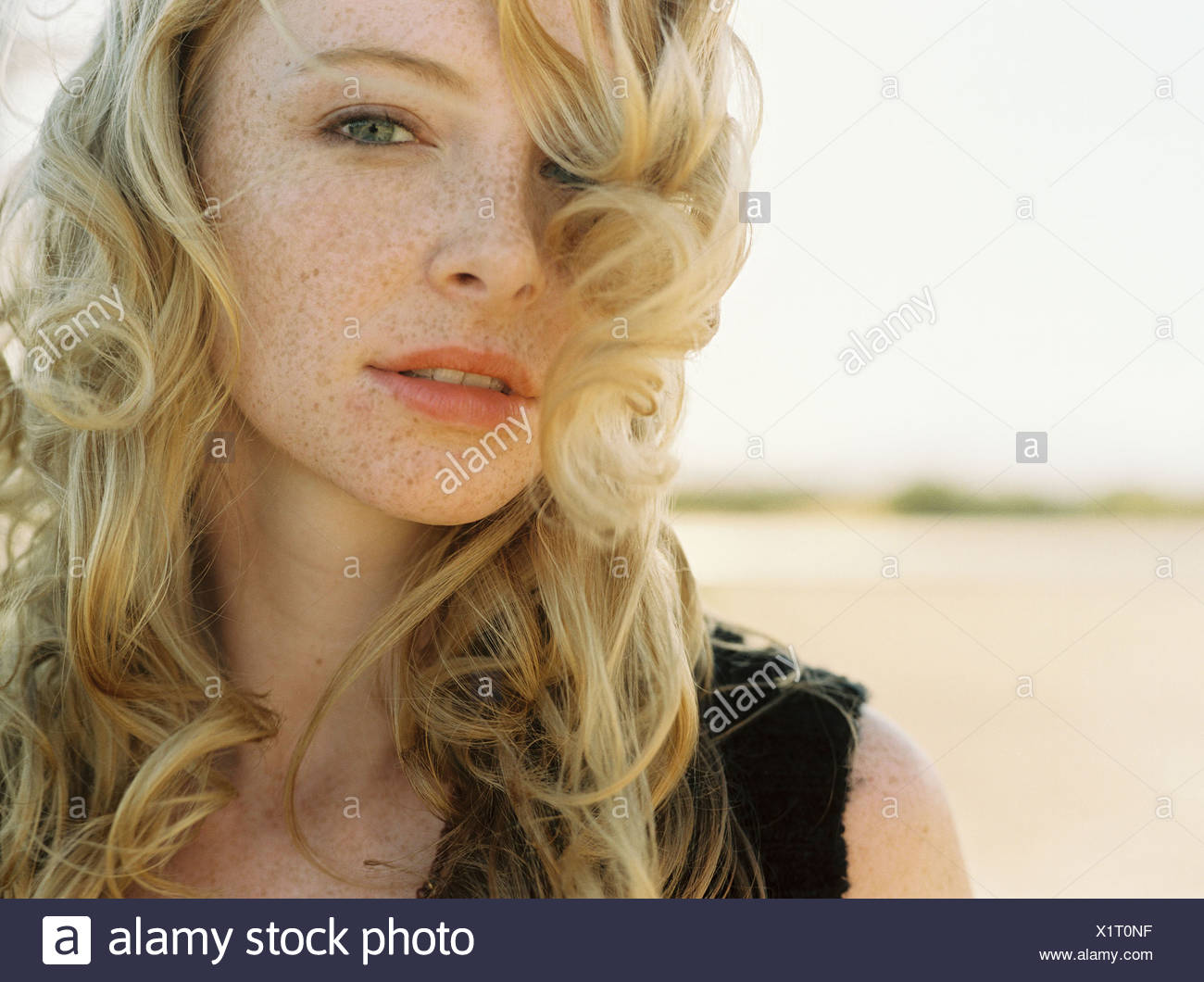 Female With Long Curly Blonde Hair And Freckles Stock Photo