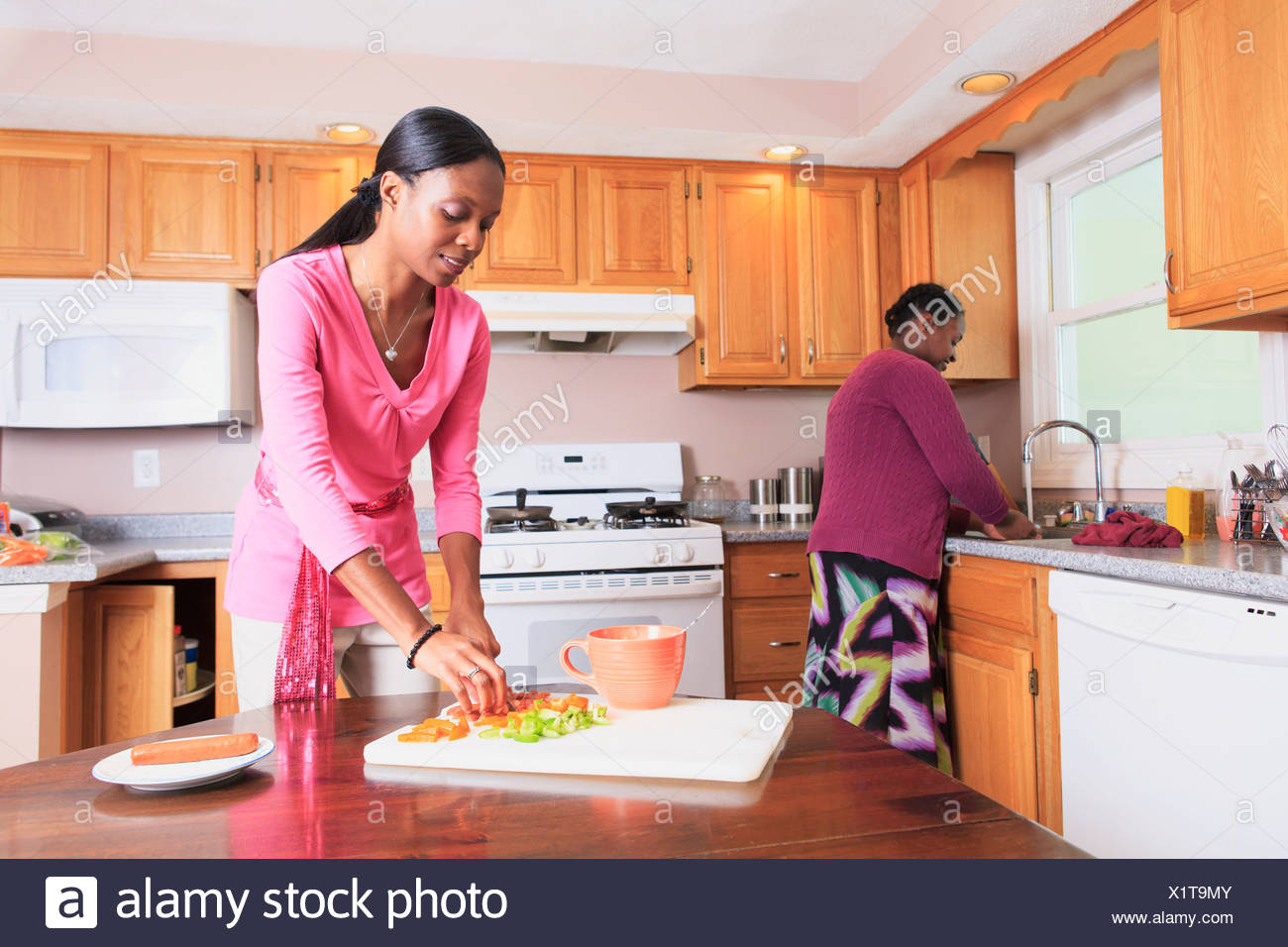 Two Sisters Working In The Kitchen One With Learning Disability Stock Photo Alamy