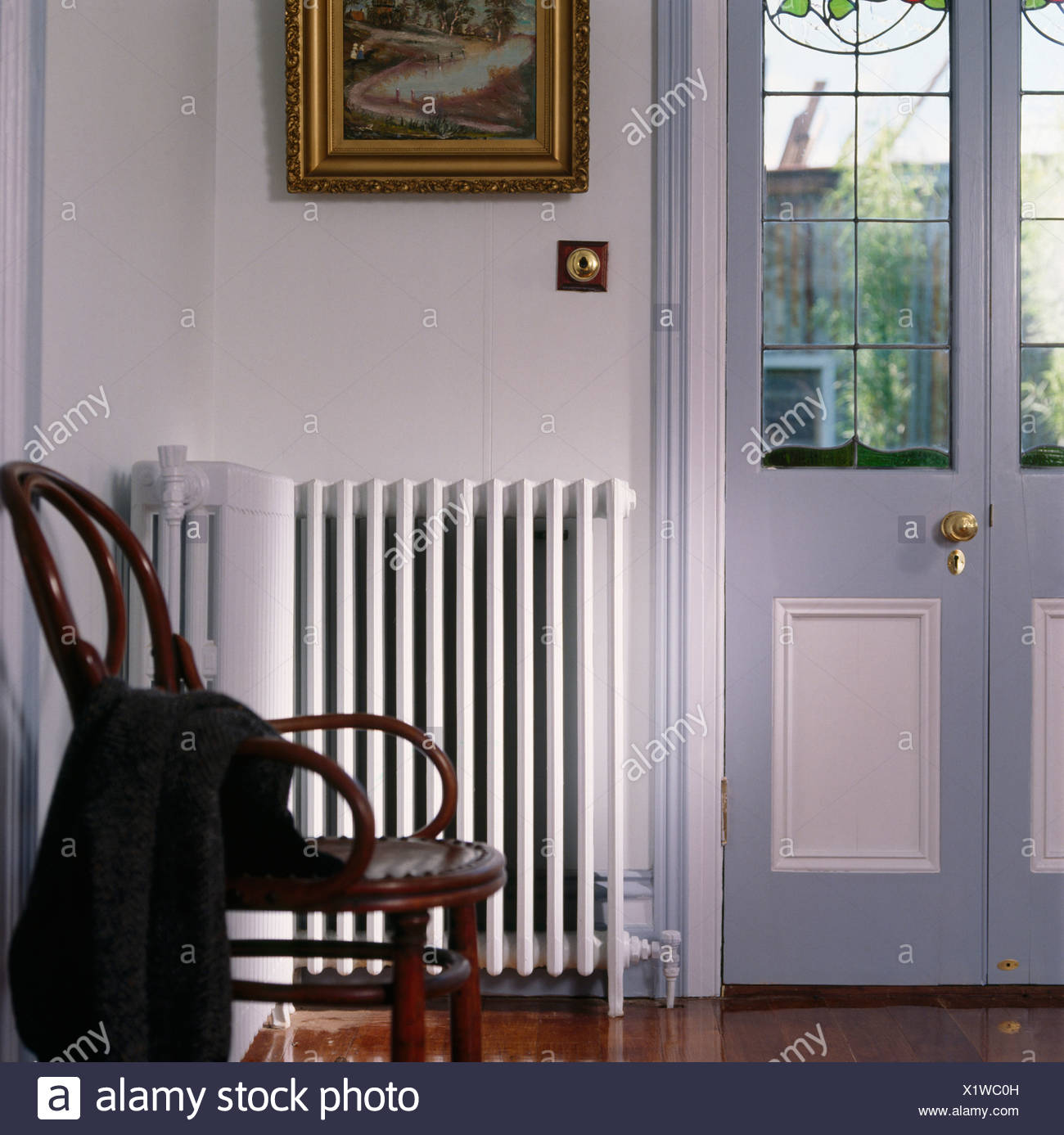 Antique Bentwood Chair Beside White Radiator In Traditional Hall