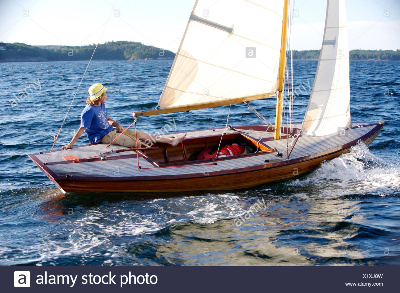 A Cheerful Teenage Boy Sails A Beautiful Wooden Dinghy In The Late Afternoon Sun On Penobscot Bay In Maine Stock Photo Alamy
