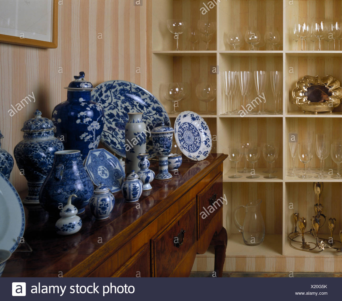 Collection Of Blue White Chinese Ceramics On Antique Side Table In Dining Room With Glassware On Cube Shelving Stock Photo Alamy