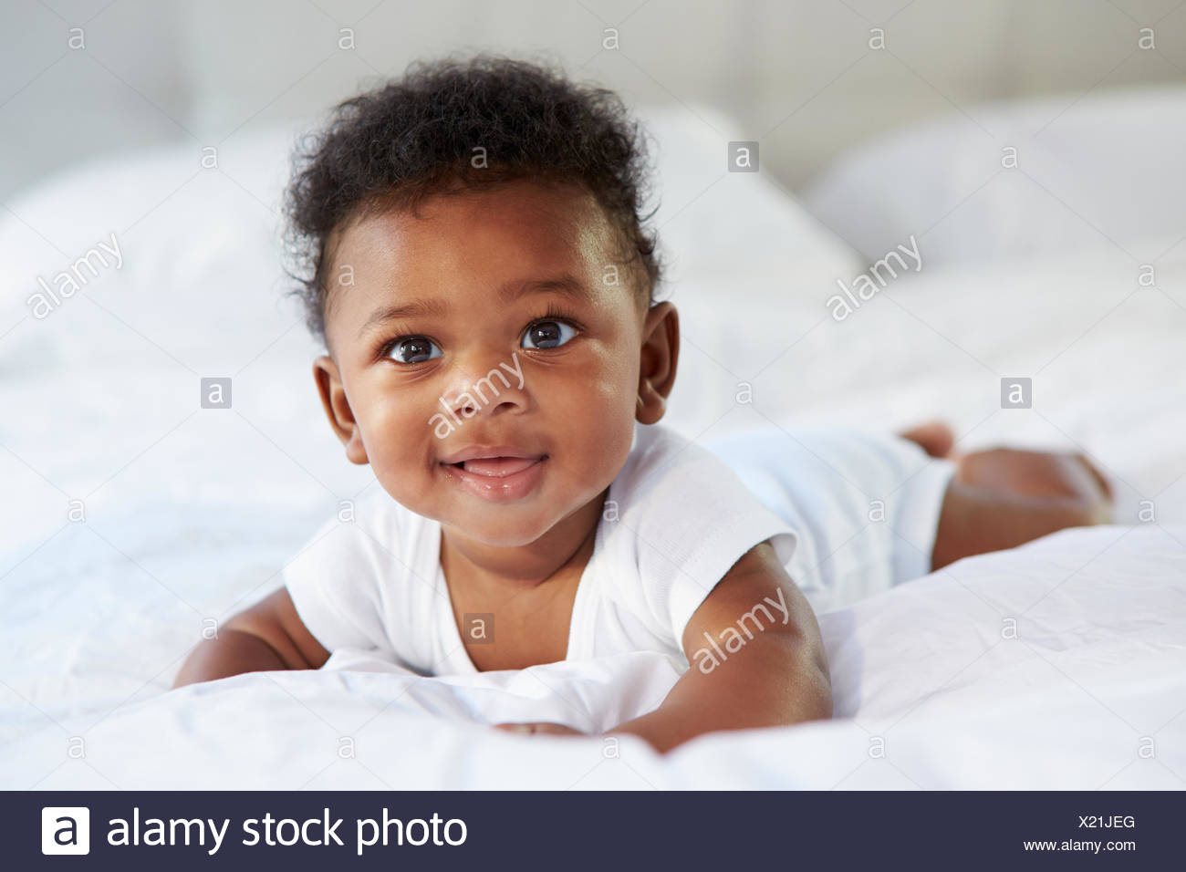 Cute Baby Lying On Tummy In Parent S Bed Stock Photo Alamy
