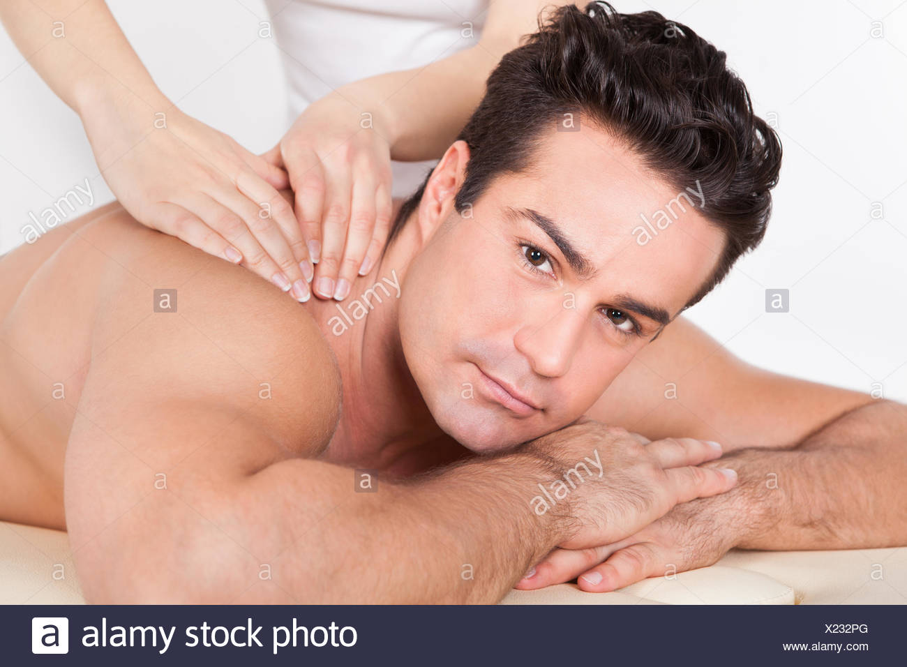 Shirtless Man Lying On Front Getting Spa Treatment Stock Photo