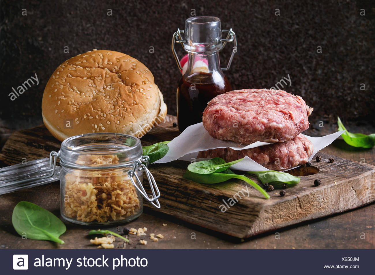 Ingredients For Making Hamburger Raw Burger Beef Cutlet Two Buns Fried Onion Fresh Spinach And Ketchup Sauce On Dark Wood Chopping Board Over Old Stock Photo Alamy