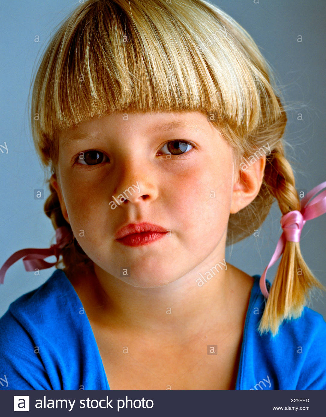 Close Up Portrait Of A Cute Little Blond Girl With Braids And