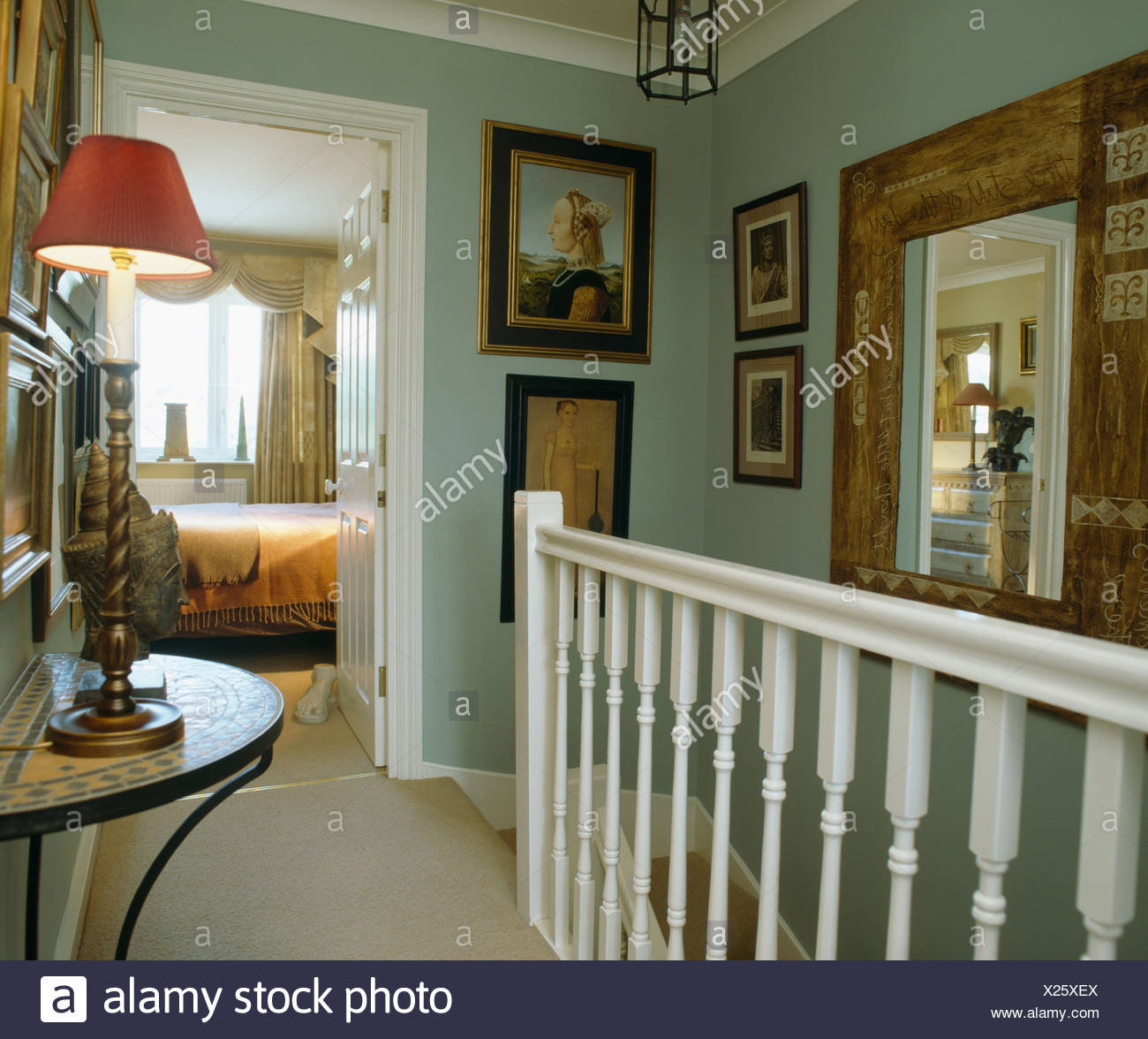 Pictures And Large Mirror On Walls Of Pale Green Landing