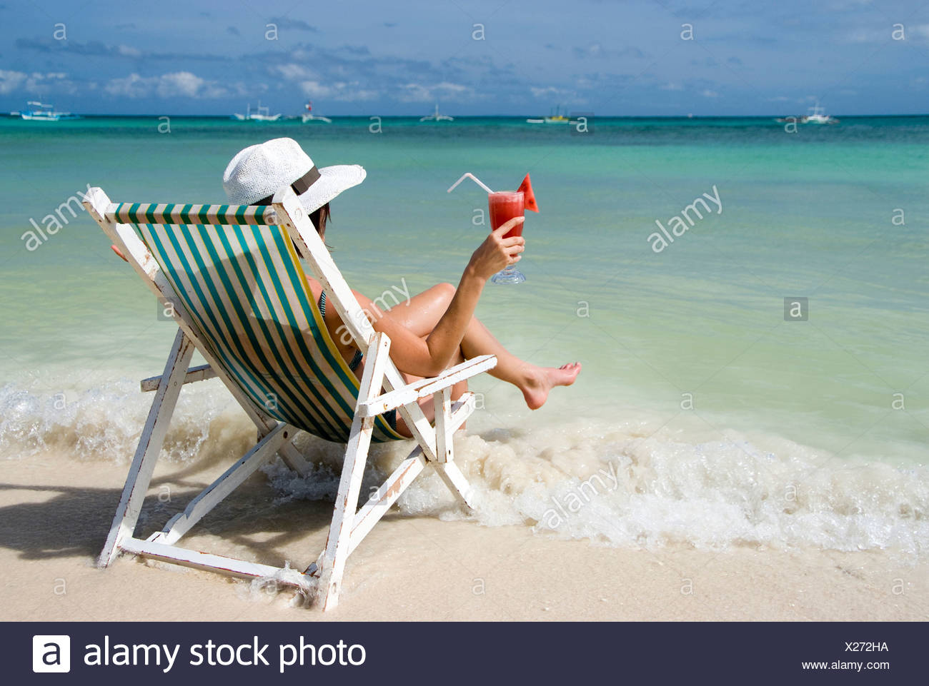 Woman With Cocktail Sits In A Folding Chair At The Beach