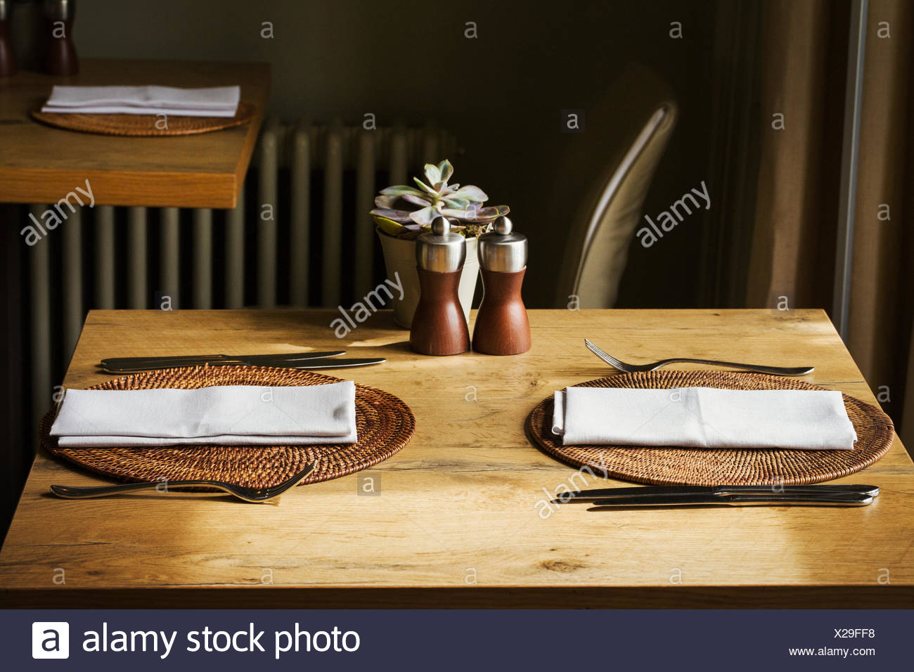Wooden Table Set With Place Mats Napkins And Cutlery In A