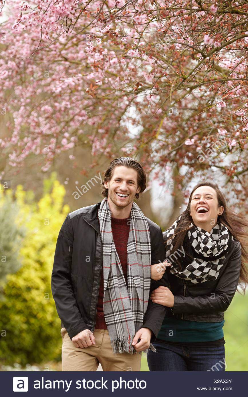 Young couple strolling and laughing in park Stock Photo