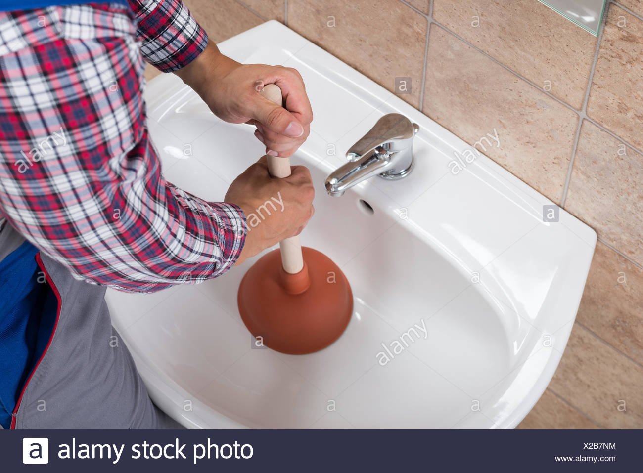 Plumber Using Plunger In Bathroom Sink Stock Photo Alamy
