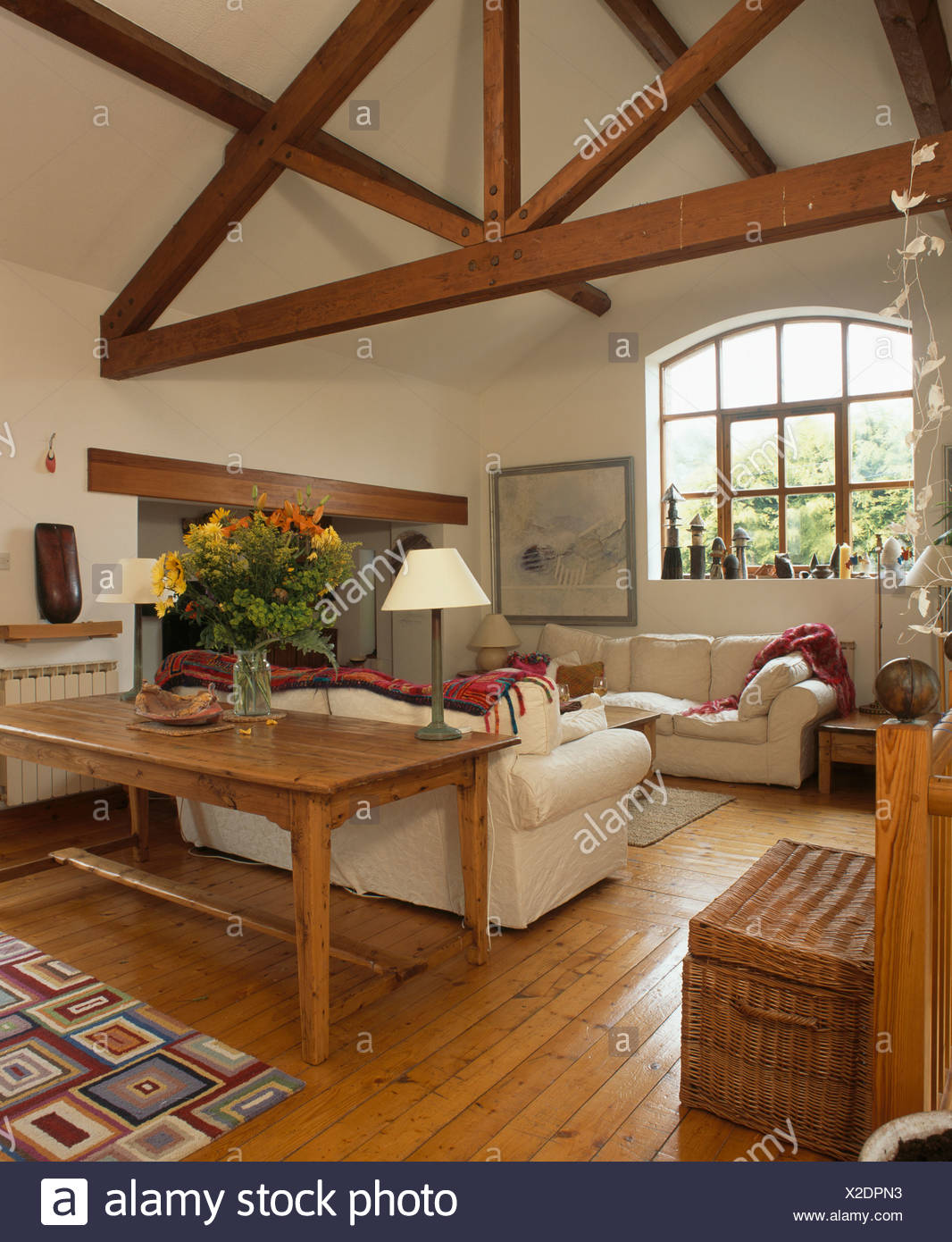 Reclaimed Wood Table And Pine Flooring With White Sofas In Living