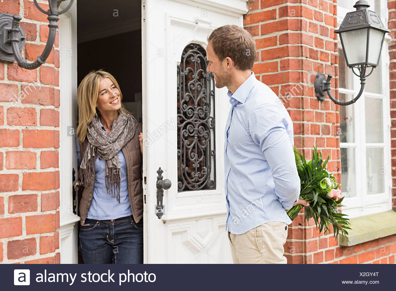 Mid Adult Couple Woman Opening Front Door Stock Photo