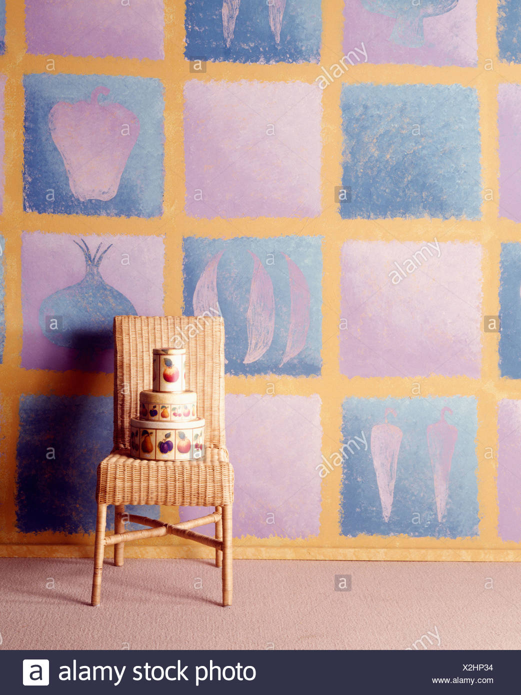 Tall Back Wicker Chair With Stack Of Circular Tins On Seat Against