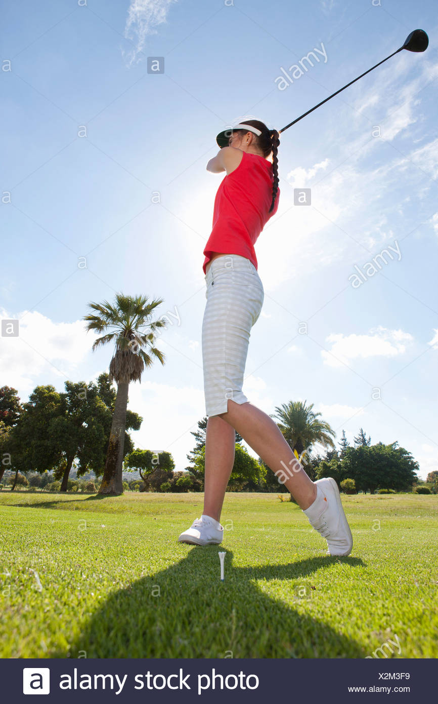Young Female Golfer Practicing Golf Swing Stock Photo